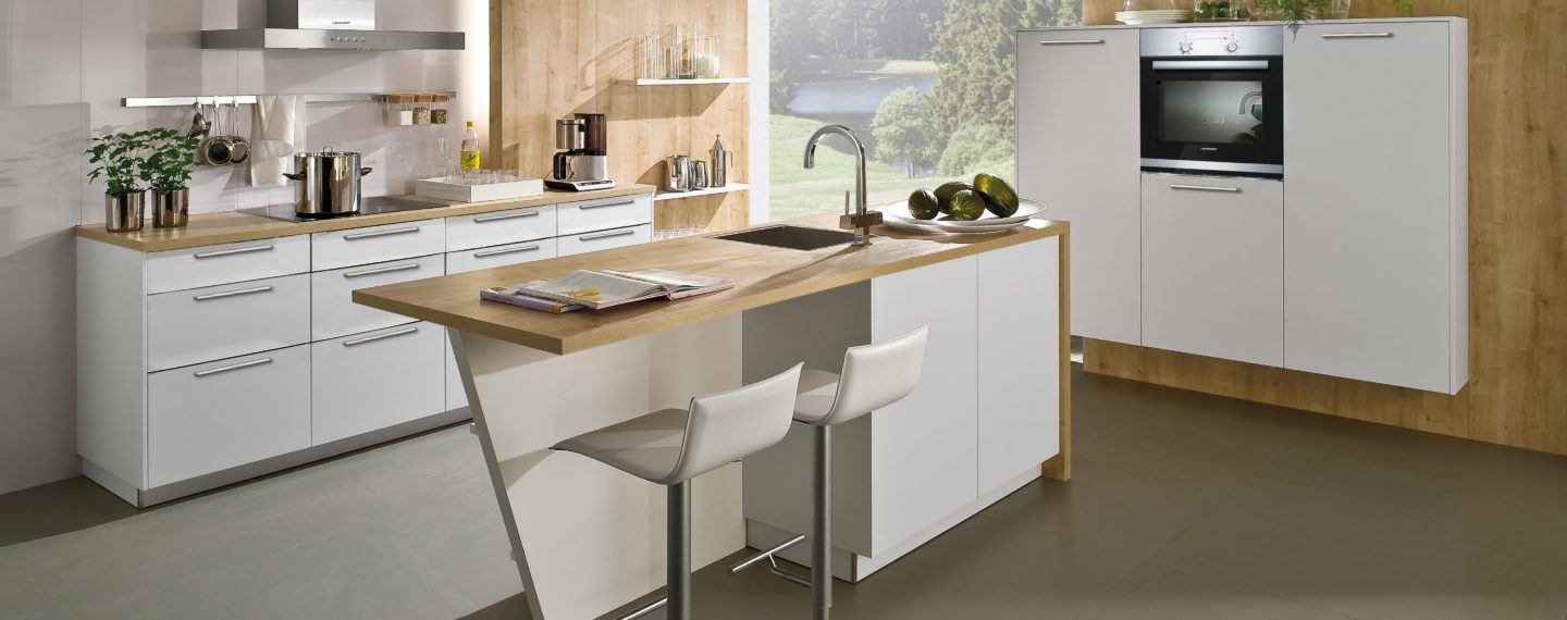 Moderne Küche mit weißen Fronten und Arbeitsplatten/Wandverkleidung in Holzoptik