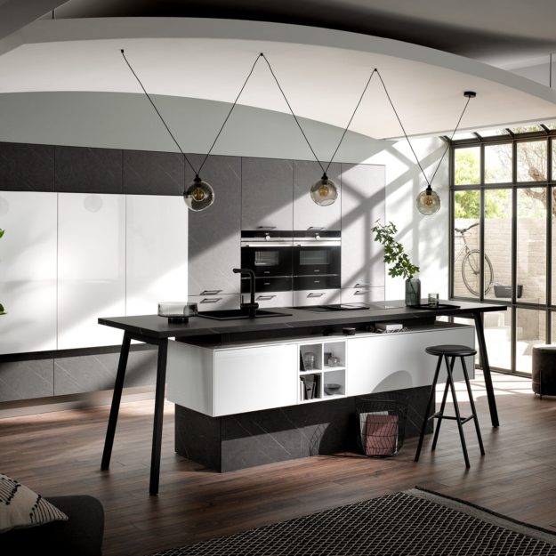 Moderne Küche mit weißen und schwarz-marmorierten Fronten und Kochinsel