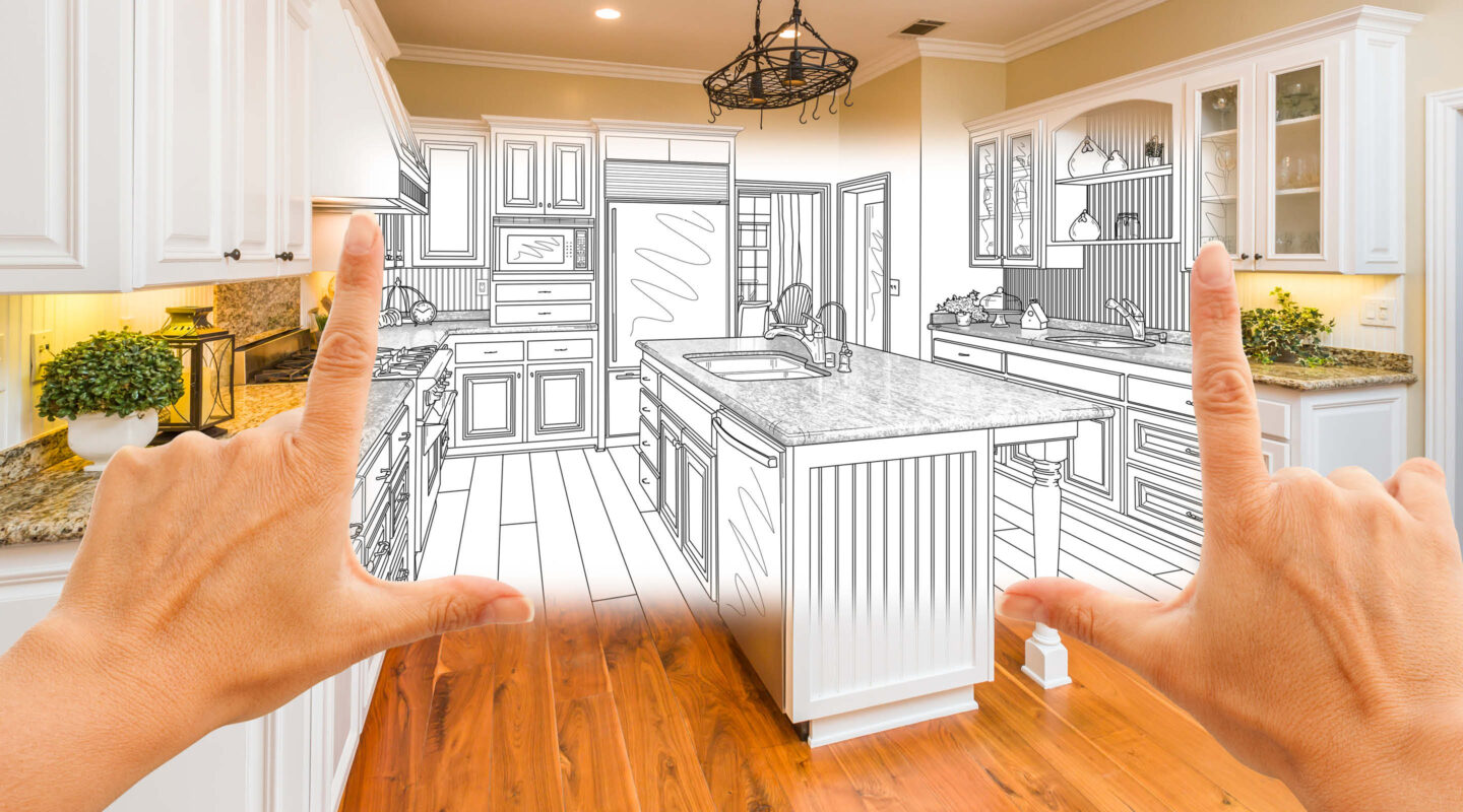 Zwei Hände spannen die Skizze einer Küche über einer Küche auf.