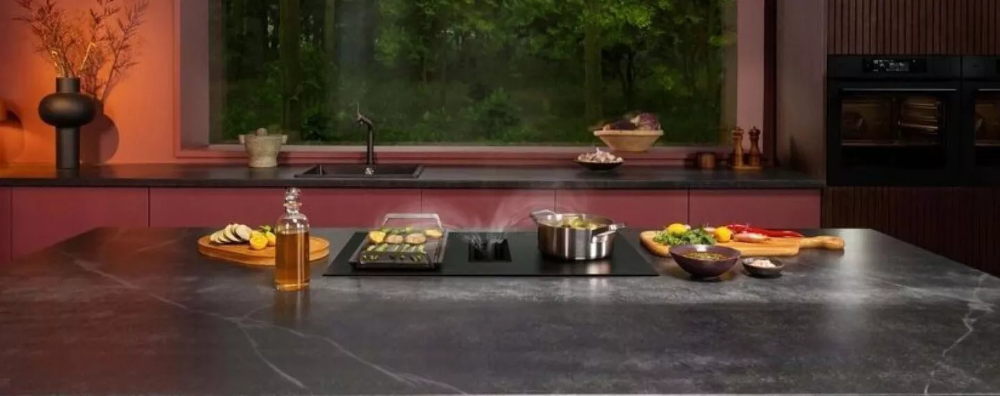 Kochszene mit geschnittenem Gemüse und Geümse auf dem Herd mit rotem Hintergrund.