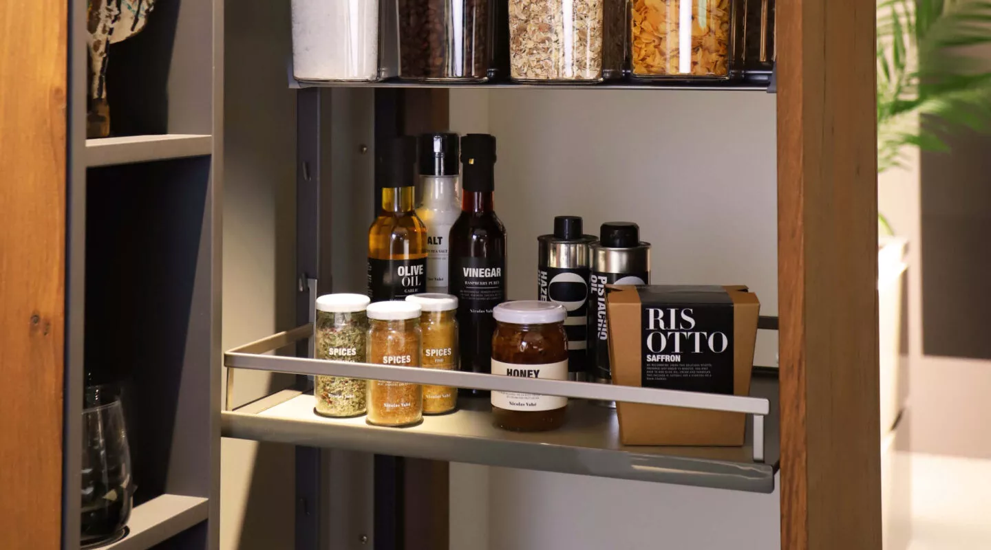 Gewürze und Öle in einem Apothekerschrank in einer Küche.
