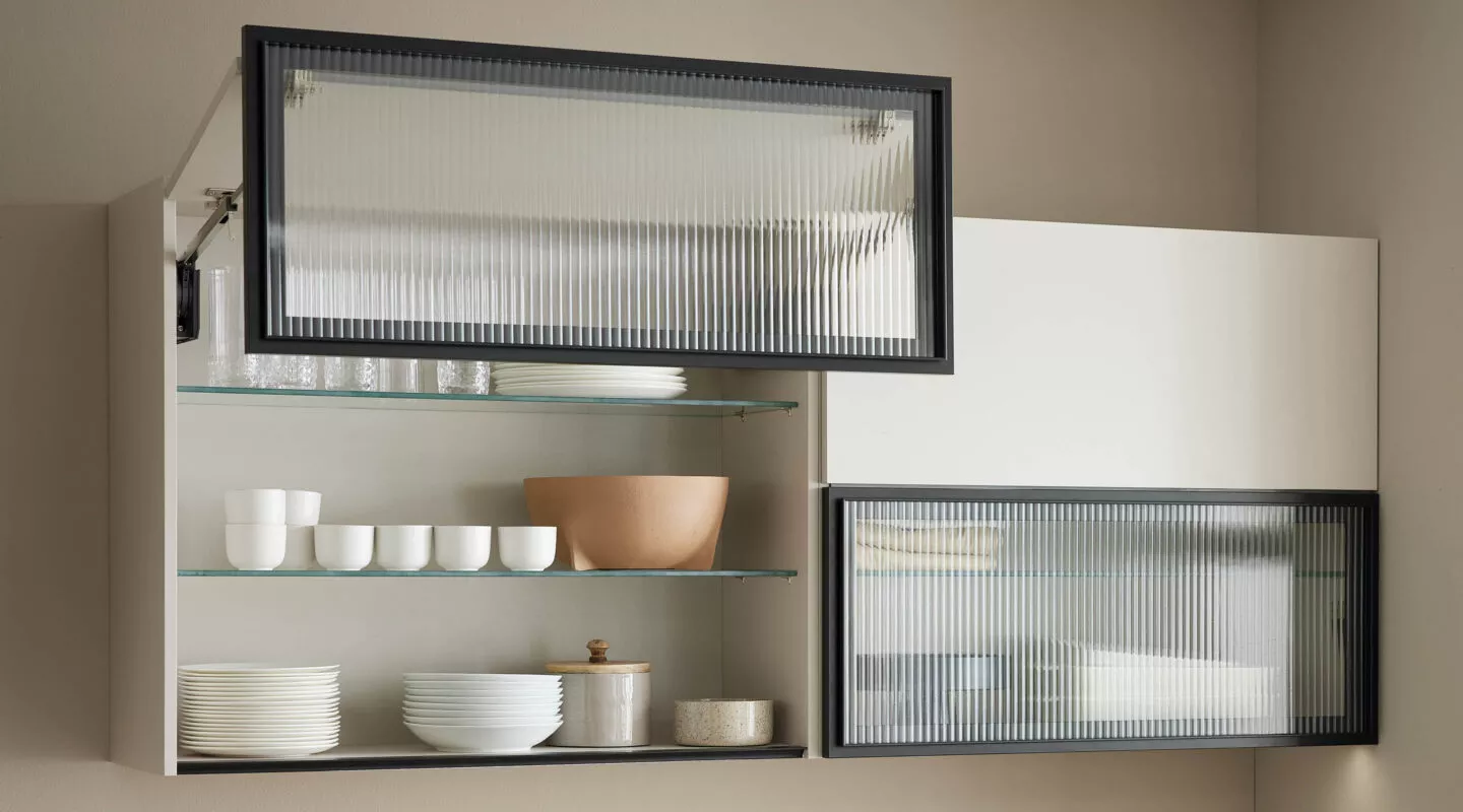 Hängeschrank in Küche mit Elementen aus geriffeltem Glas und Blick auf Geschirr