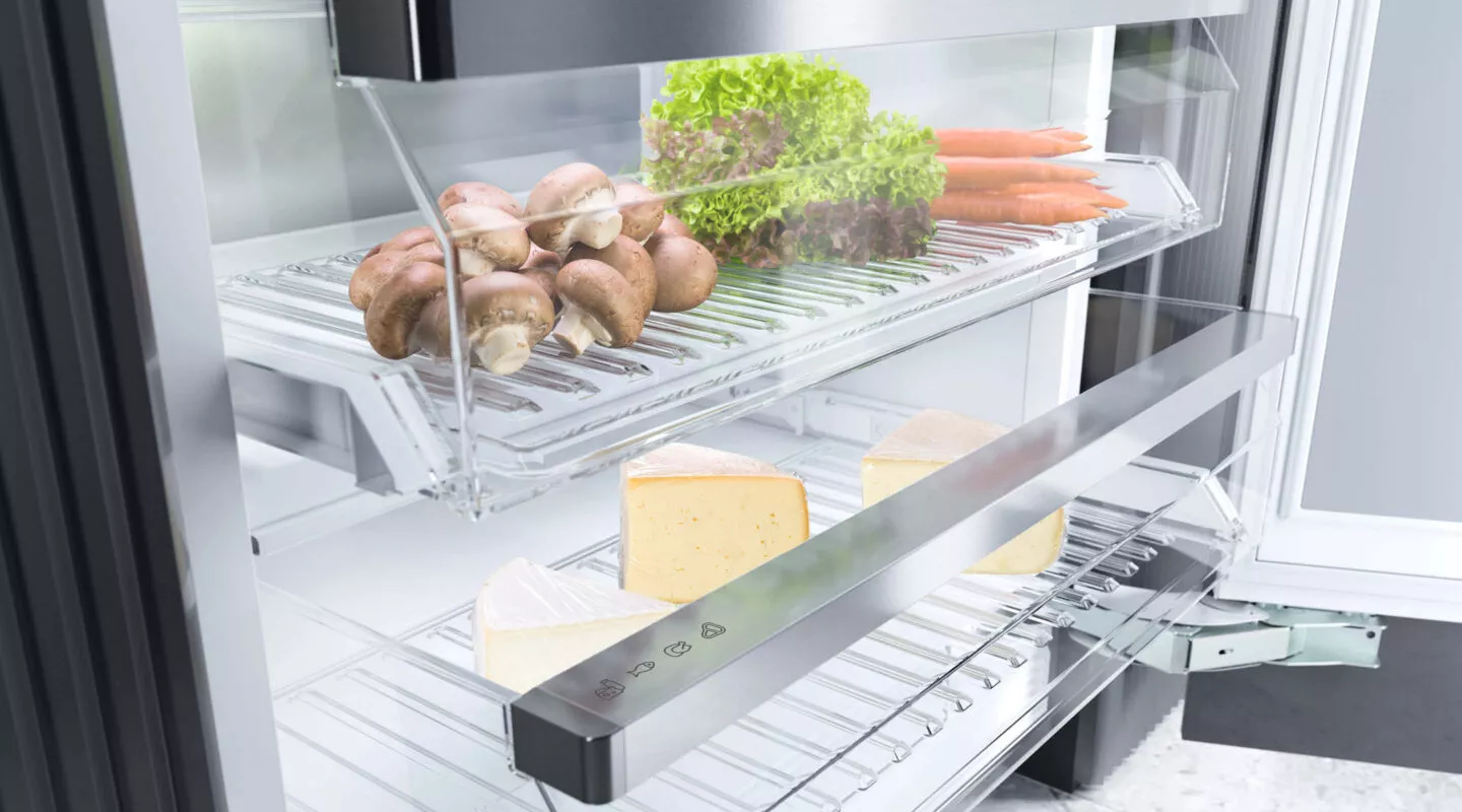 Frischezone im Kühlschrank mit Gemüse, Pilzen und Käse auf ausziehbaren Glasböden für optimale Lagerung und längere Haltbarkeit.