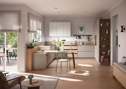 Moderne offene Wohnküche von Häcker mit beigen Fronten, heller Holzoptik, integriertem Essplatz, viel Tageslicht und fließendem Übergang zum Wohnzimmer.